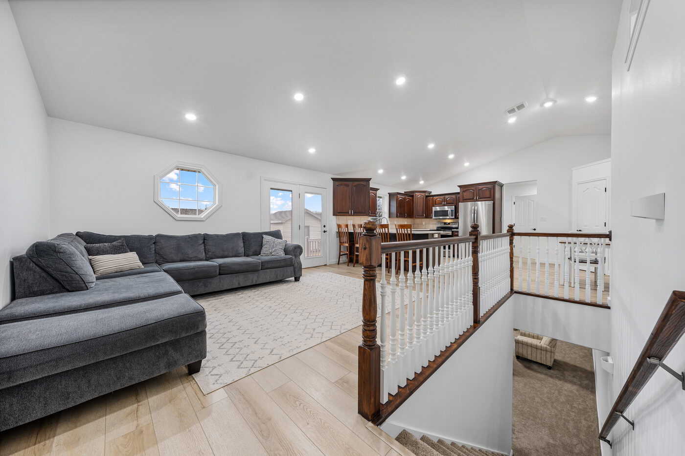 Living room showing stairway railing and open flow to kitchen — Hidden Valley home